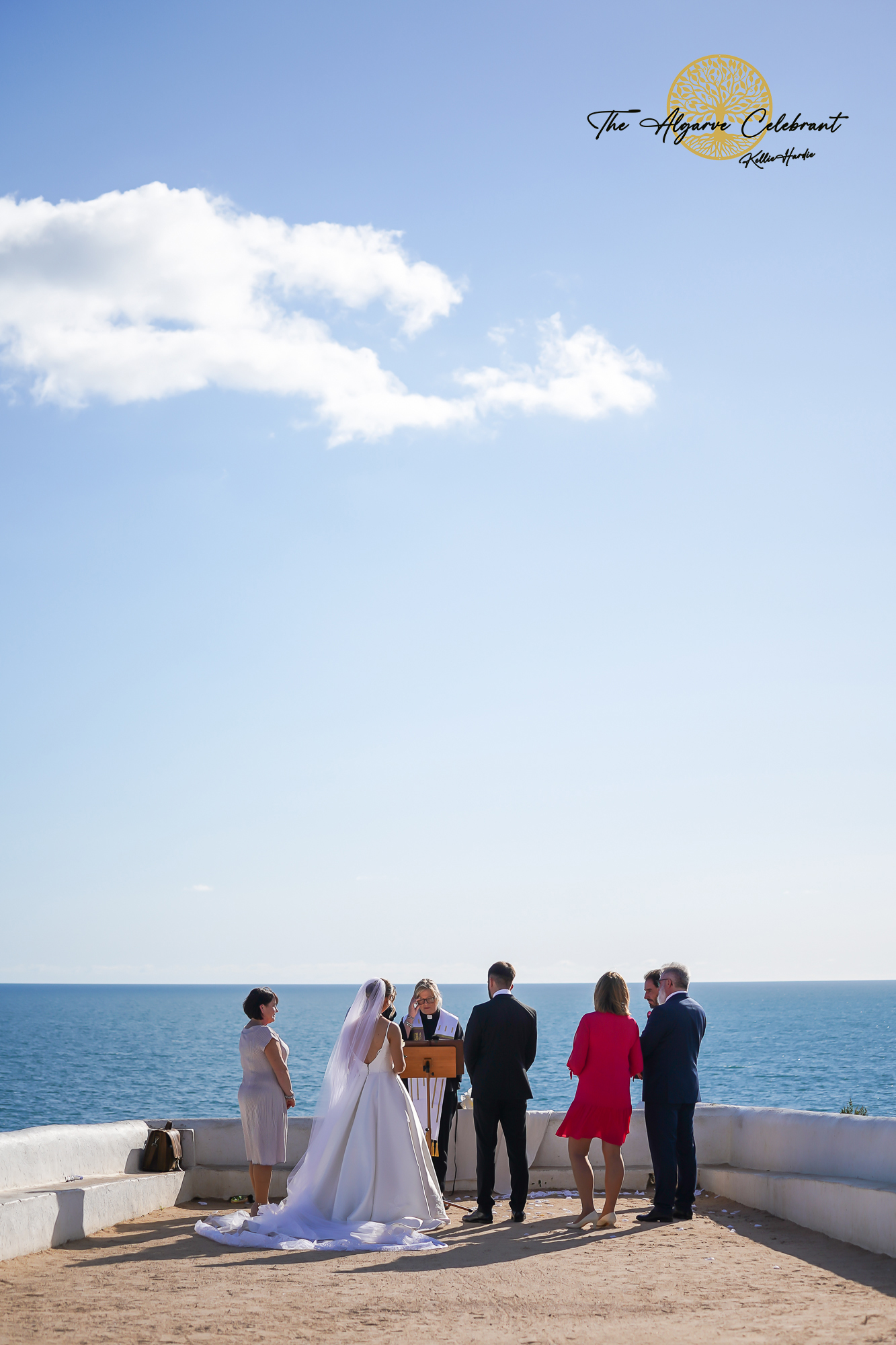 The Couple Outside the Chapel: Daniel and Magdalena standing together outside Senhora da Rocha chapel, holding hands and smiling against the backdrop of the ocean.